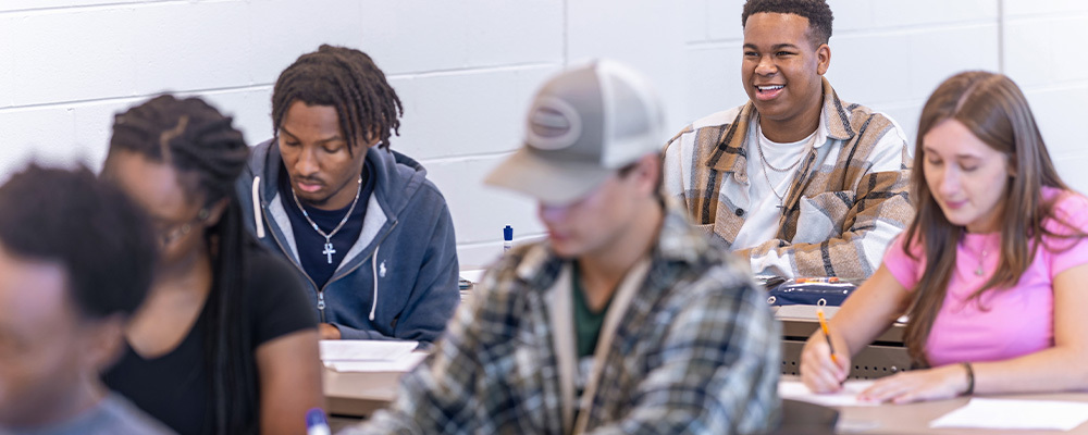 A group of students taking notes in a classroom