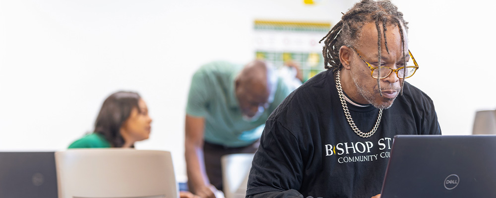 Older male student with glasses workng on his dell laptop