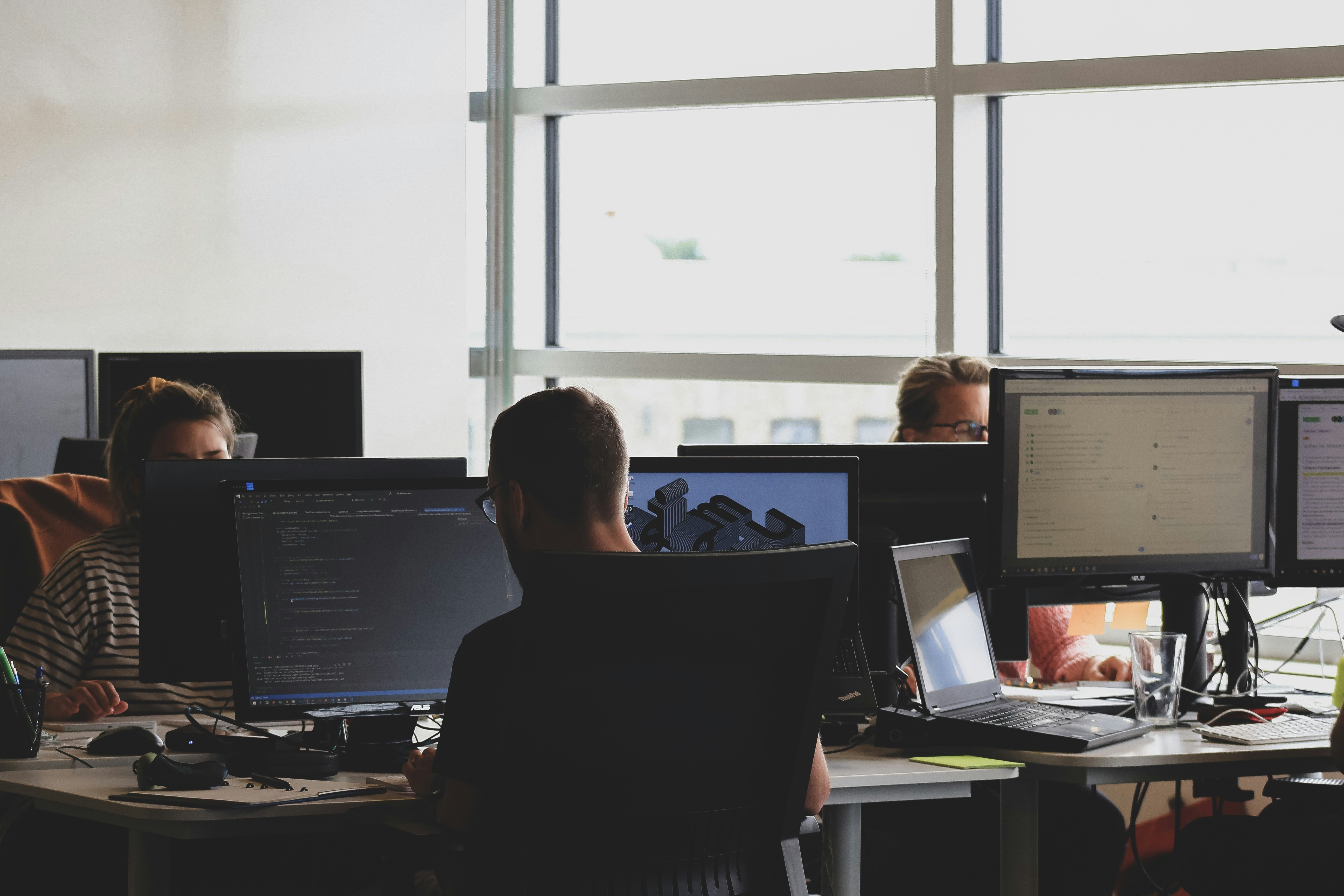 A group of programmers in a open space office working on code